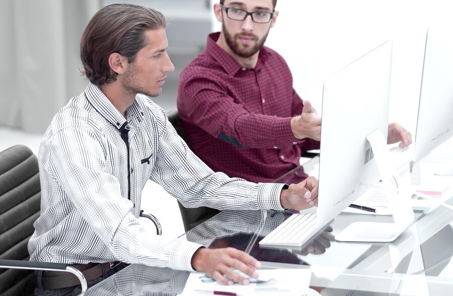 it-staff-two-employees-sitting-front-computer-monitors_252847-20203-min