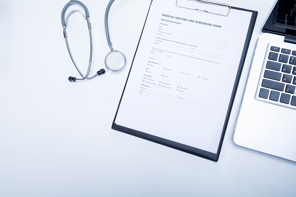 top-view-doctor-desktop-with-stethoscope-clipboard-with-medical-records-form-computer-laptop