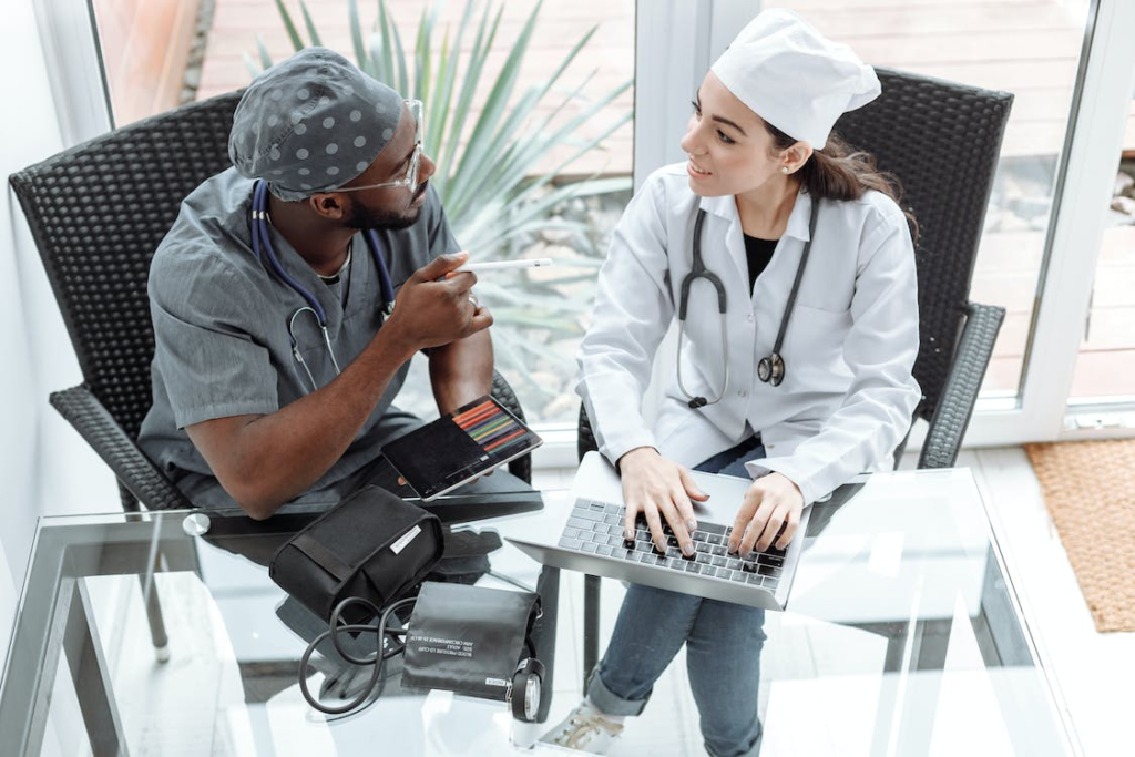 Medical professionals sitting on a chair in front of a glass table while having a conversation