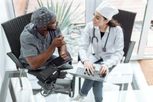 Medical professionals sitting on a chair in front of a glass table while having a conversation