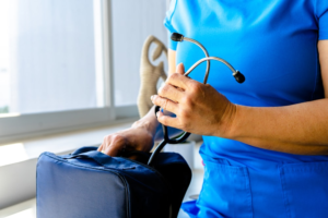 An image of a woman in scrubs holding a stethoscope