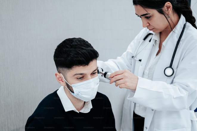 Doctor checking a man’s ear