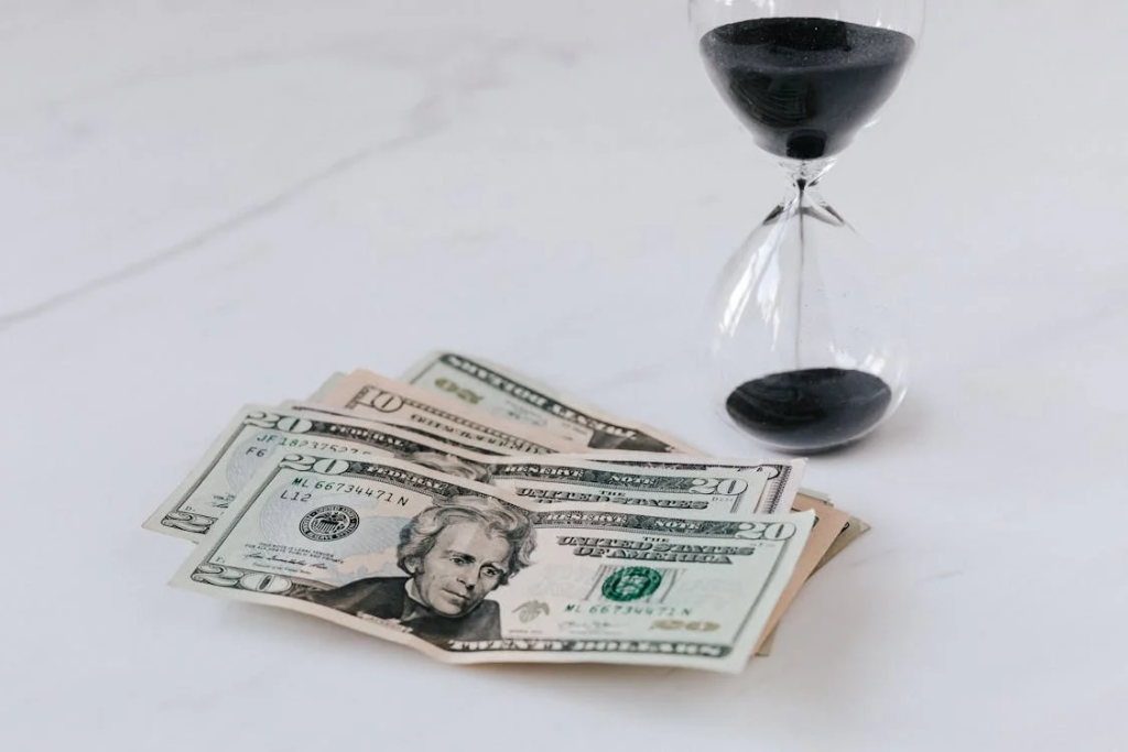 Dollar notes next to an hourglass