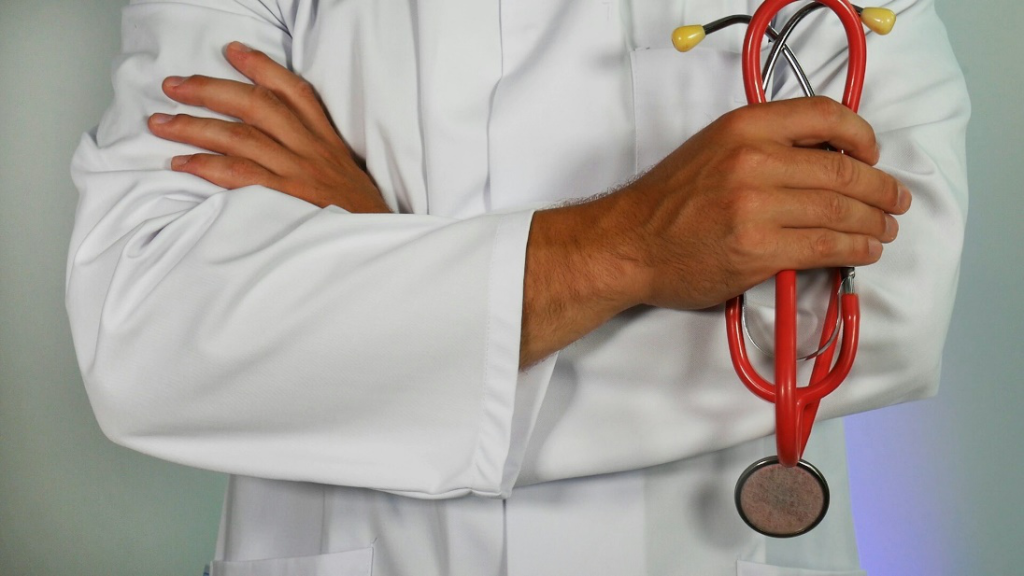 Doctor holding a red stethoscope.