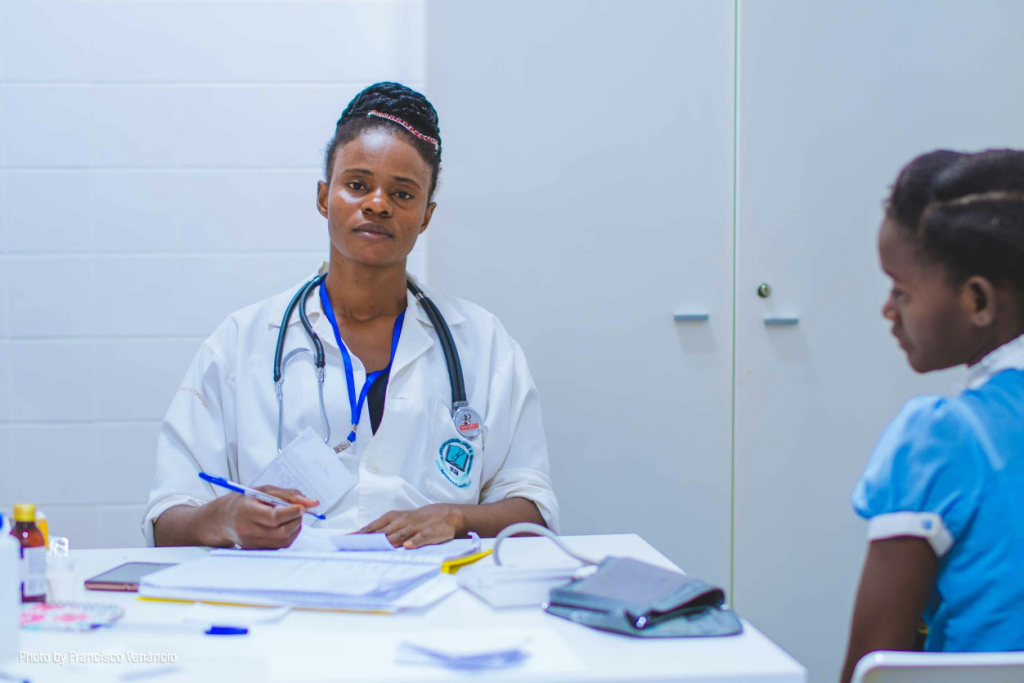 A doctor sitting at a table with a young patient